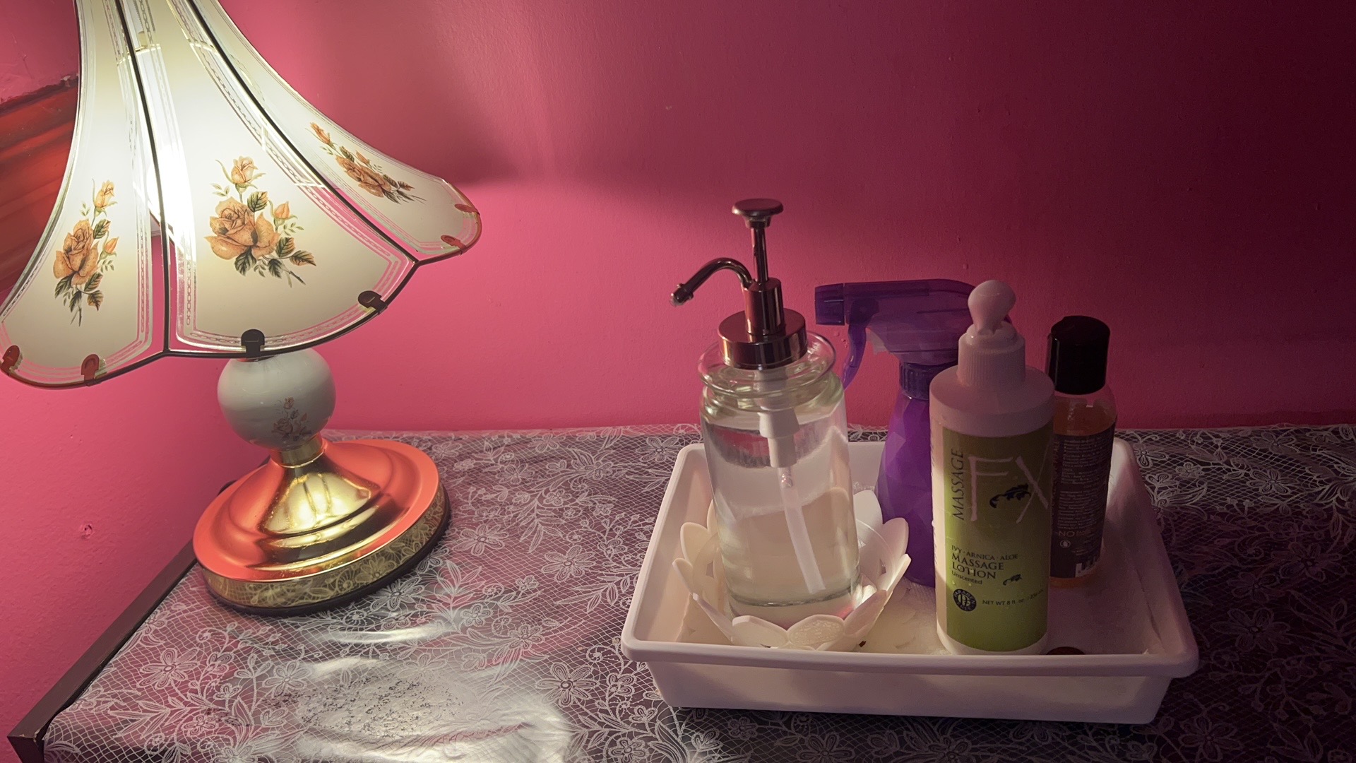 A lamp and massage lotions on a table in a treatment room